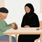 أم تلعب لعبة التخمين باللمس مع طفلها، الطفل معصوب العينين ويحاول التعرف على الصنوبر عن طريق اللمس